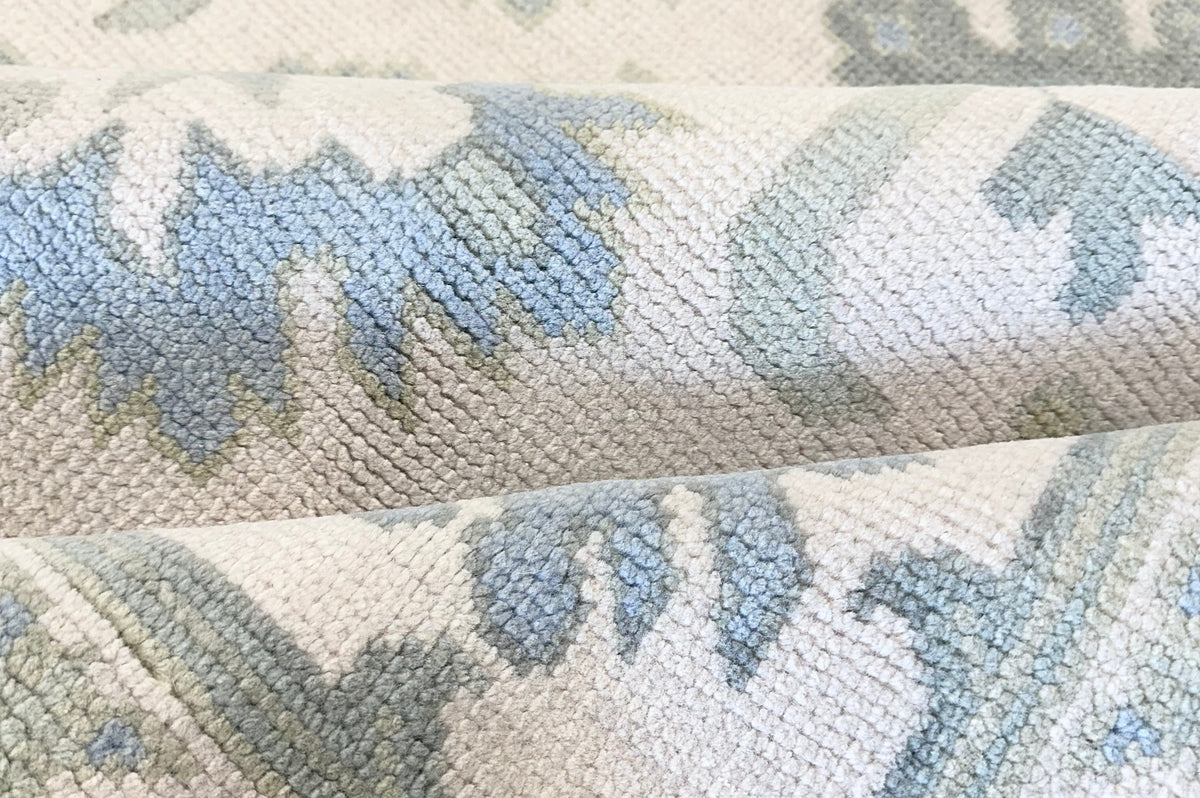 Wool Oushak rug with green and blue floral pattern on a white background hand-knotted