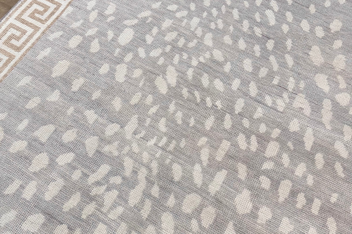 Close up Oushak animal print leopard rug with greek key border