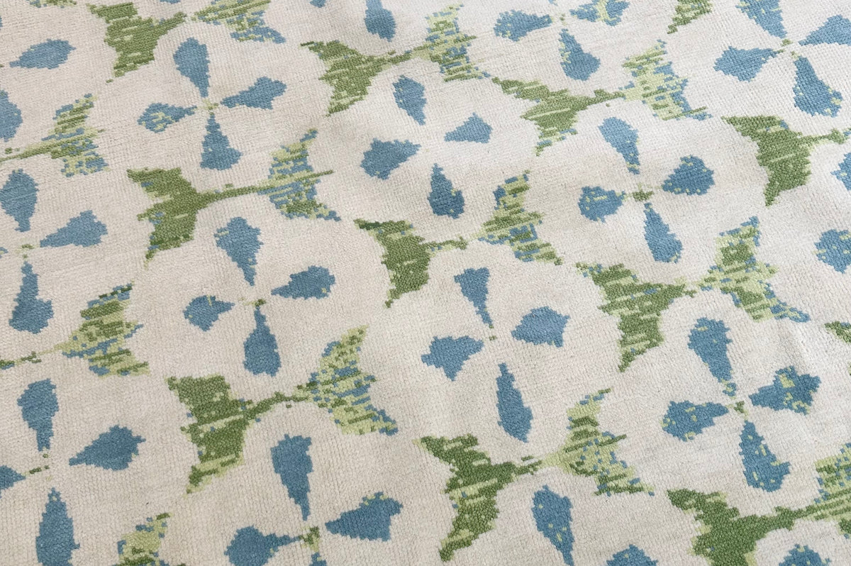 Patterned carpet with blue and green shapes on a neutral background
