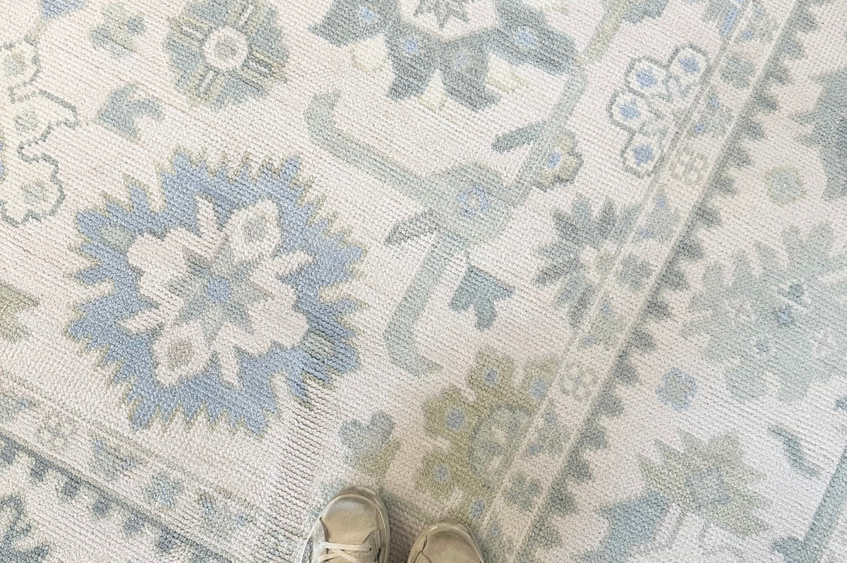 Wool Oushak rug with green and blue floral pattern on a white background hand-knotted