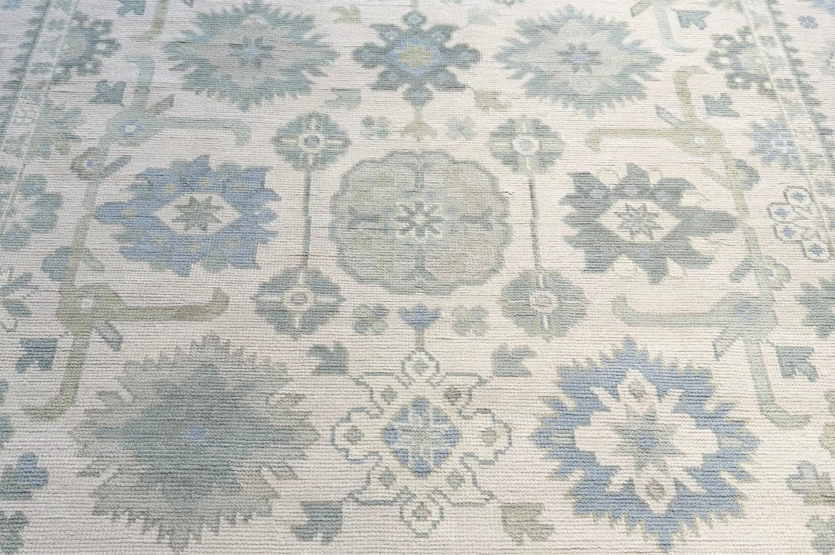 Wool Oushak rug with green and blue floral pattern on a white background hand-knotted
