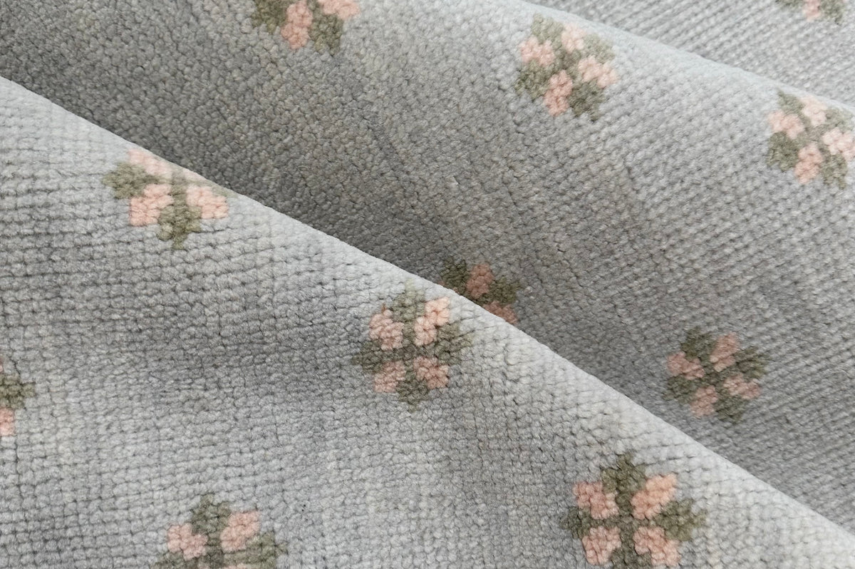 Wool rug with green and pink floral pattern on a blue background hand-knotted