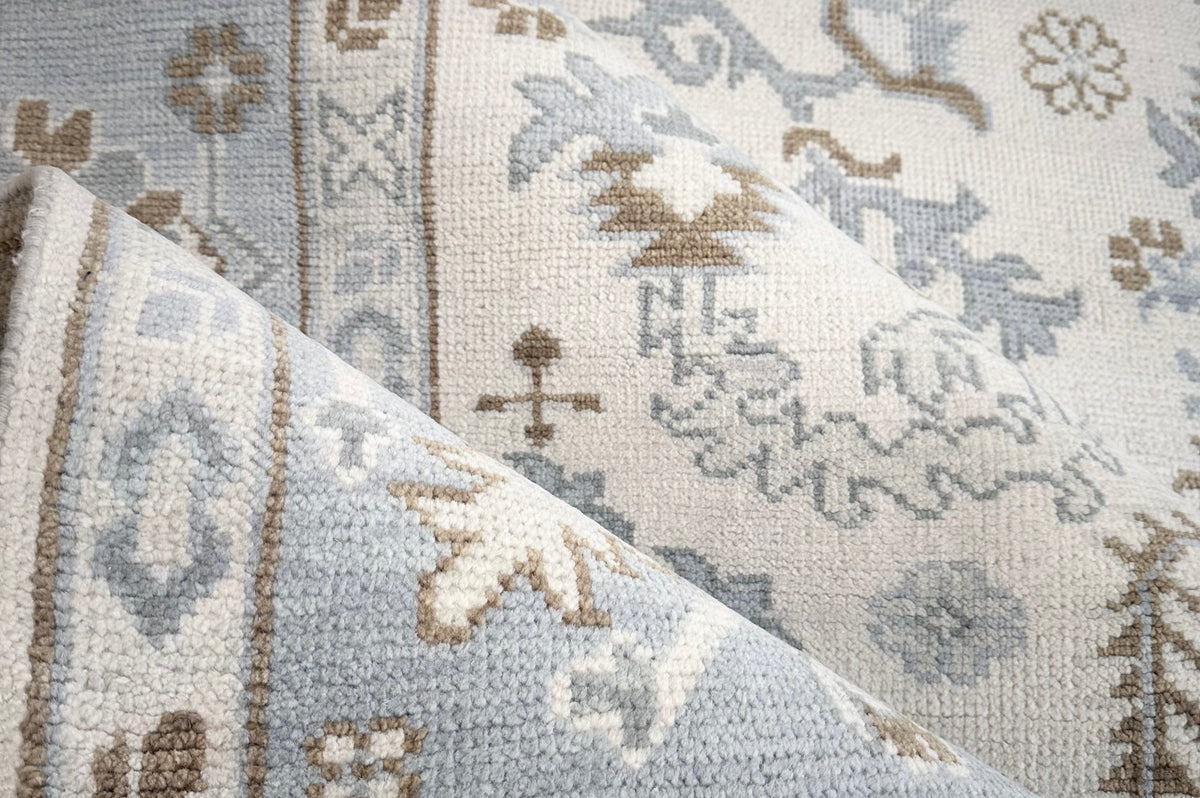 Close-up of a patterned rug with geometric designs in blue, brown, and beige.