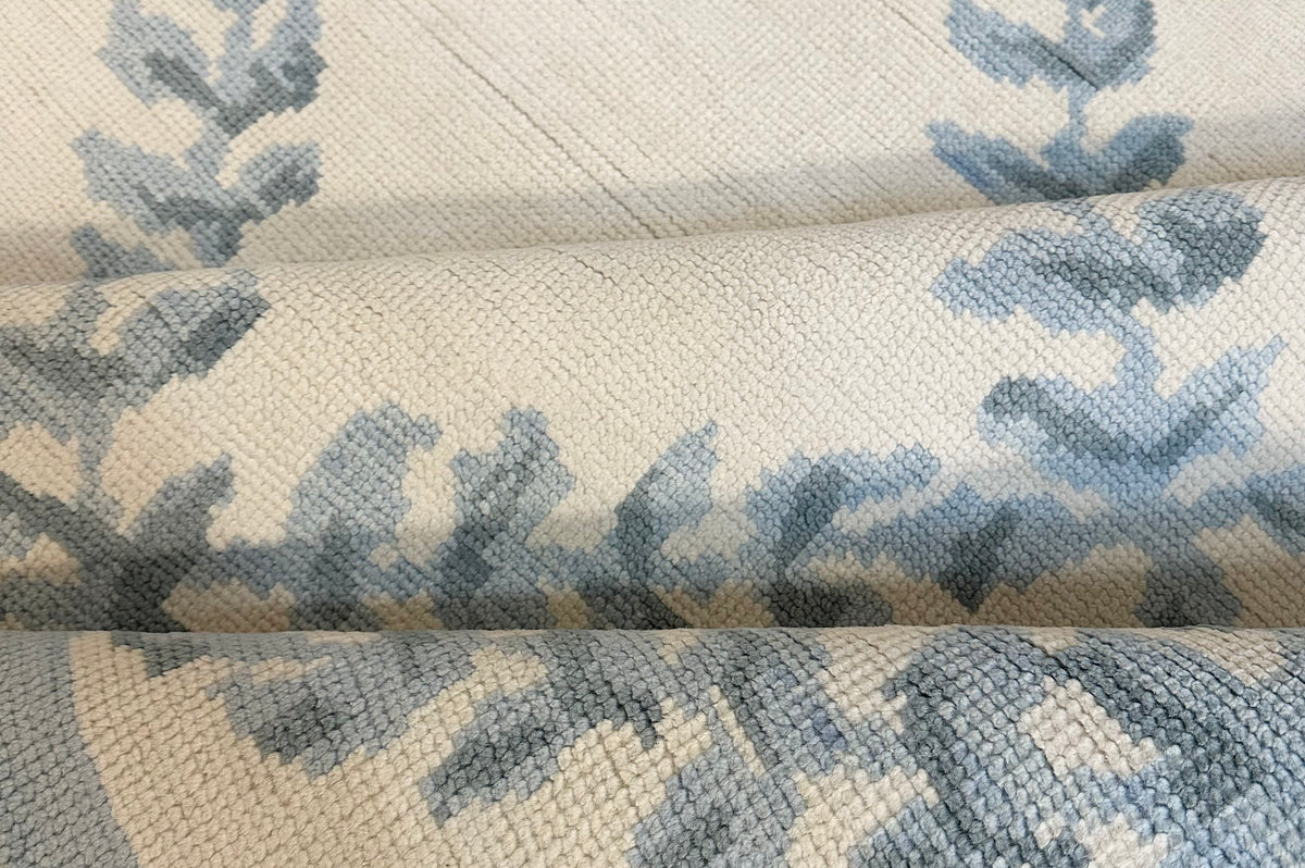 Wool rug with blue leaf pattern on a beige background hand-knotted