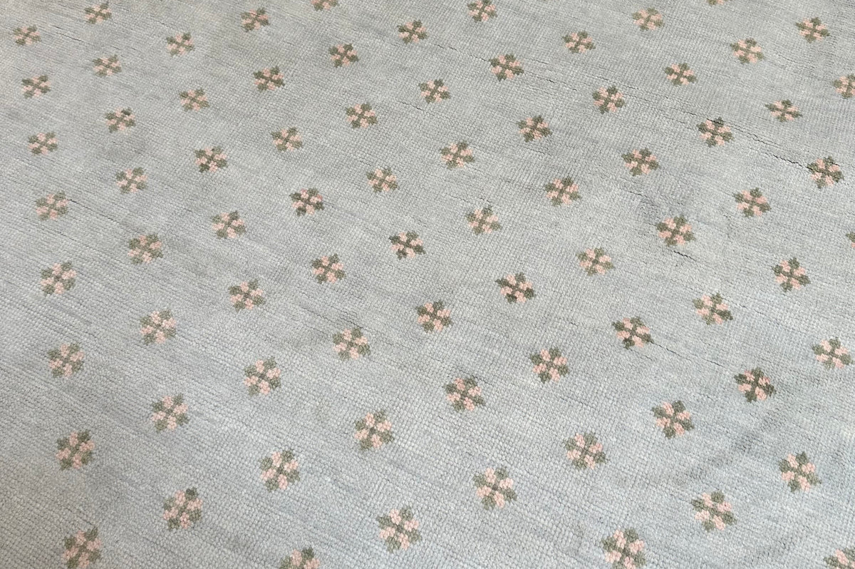 Wool rug with green and pink floral pattern on a blue background hand-knotted